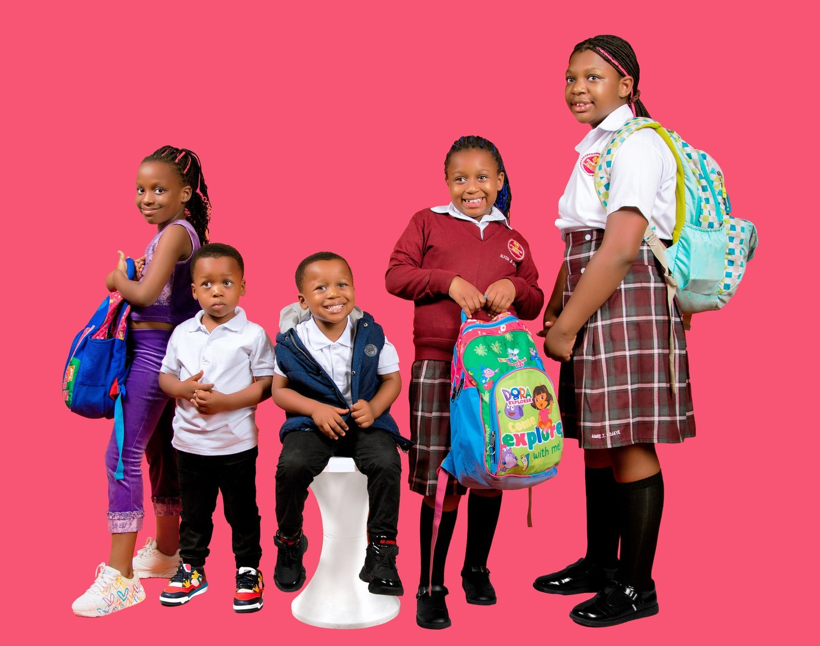 Five children in school uniform with shoes and backpacks from Kicks and Packs in Kira, Uganda
